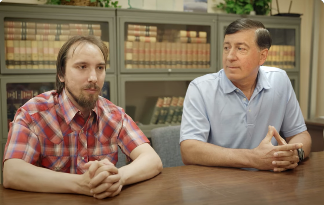 Nick and his father seated together at a table
